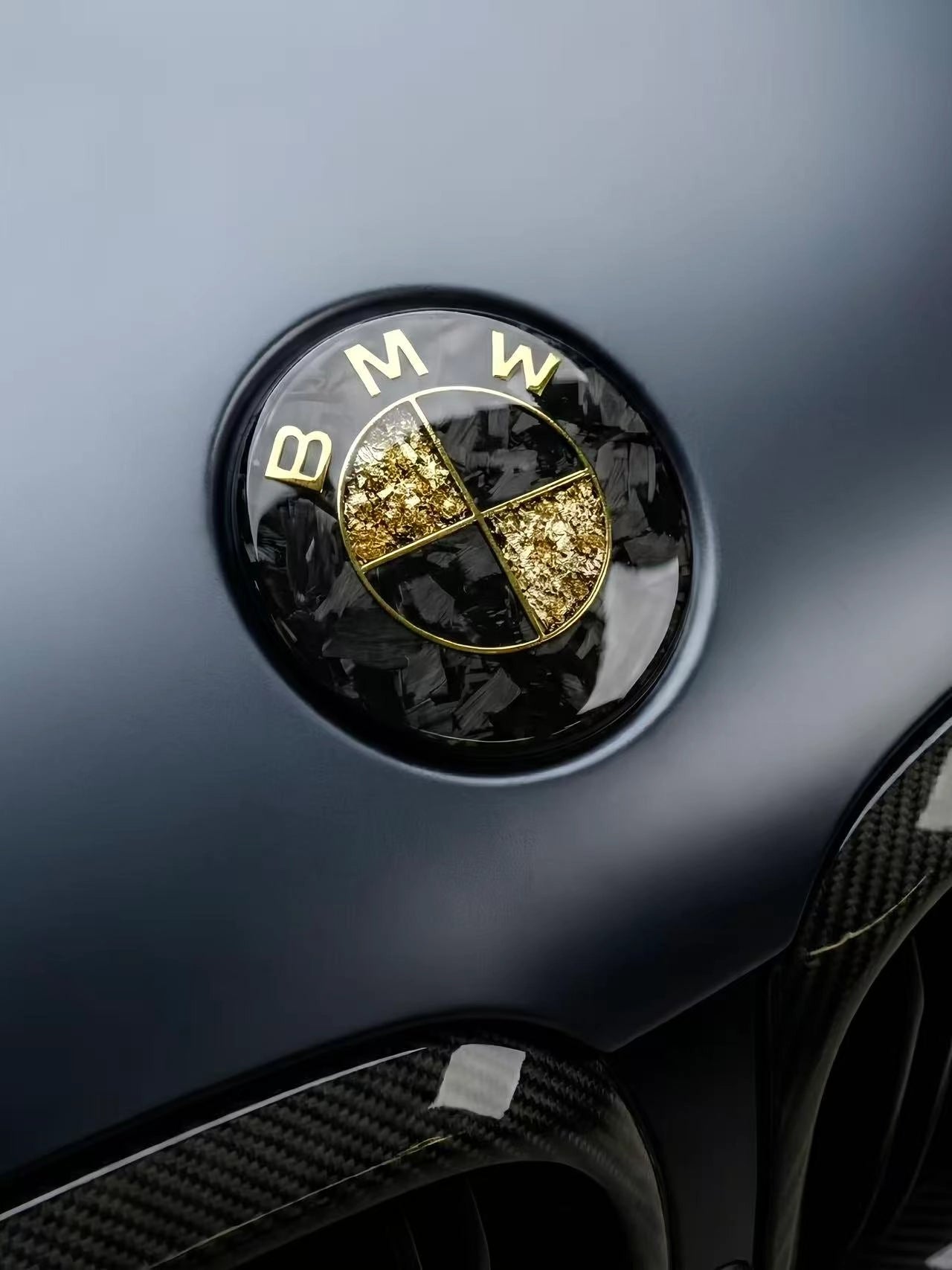 Forged carbon fiber and gold leaf custom roundel badge by REVMODE