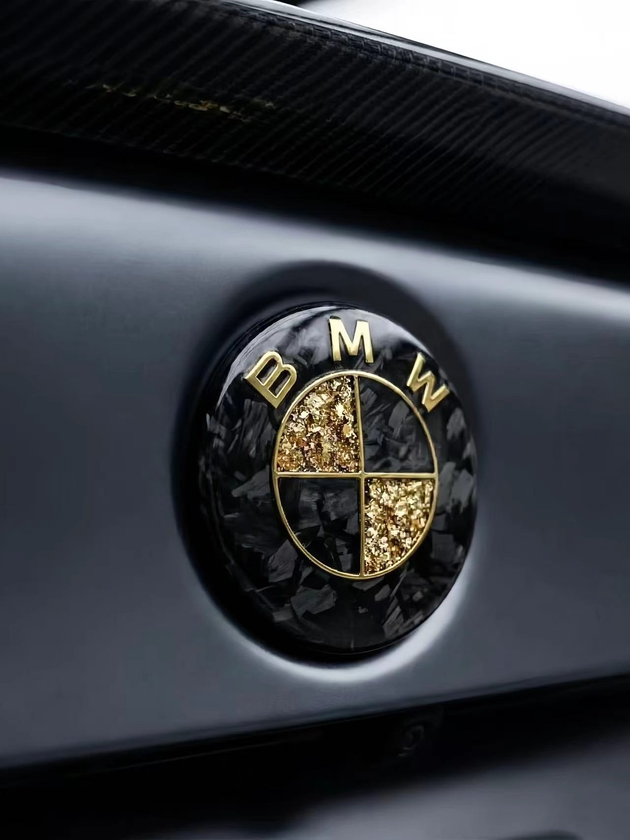 Forged carbon fiber and gold leaf custom roundel badge by REVMODE