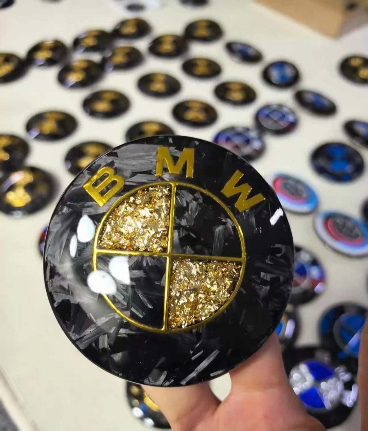 Forged carbon fiber and gold leaf custom roundel badge by REVMODE